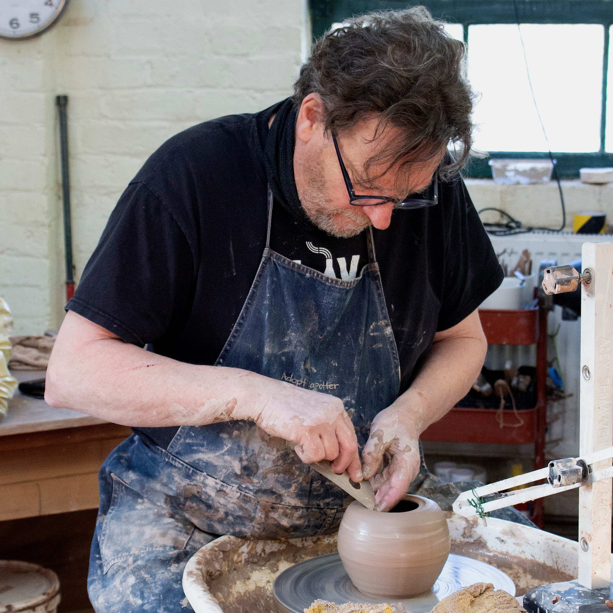 Kevin Millward using stainless steel pottery rib to put in a gallery for lid