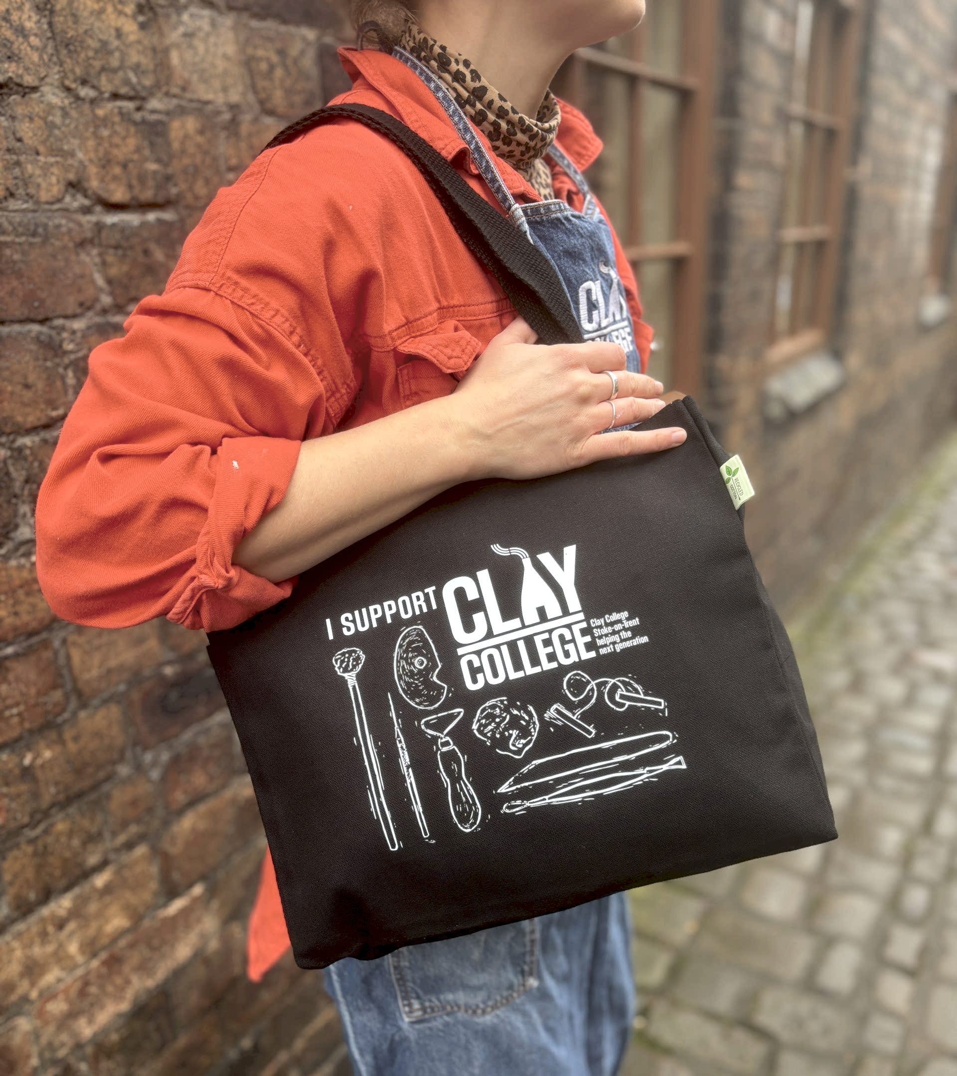 Black shopper style tote bag image modelled by Clay College student